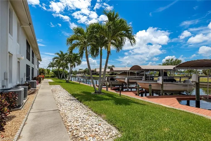 Dock featuring boat lift, a yard, and a water view