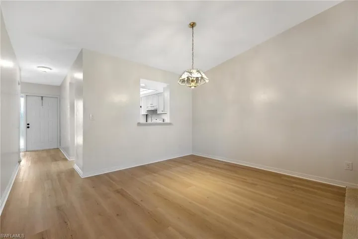 Unfurnished dining area featuring light wood finished floors and a chandelier