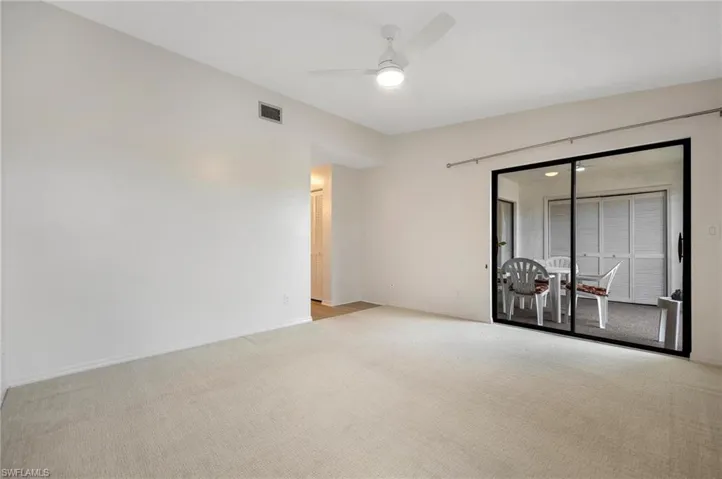 Carpeted empty room featuring baseboards and ceiling fan