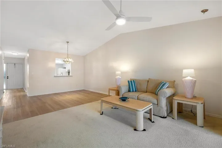 Living area featuring vaulted ceiling, wood finished floors, and a ceiling fan
