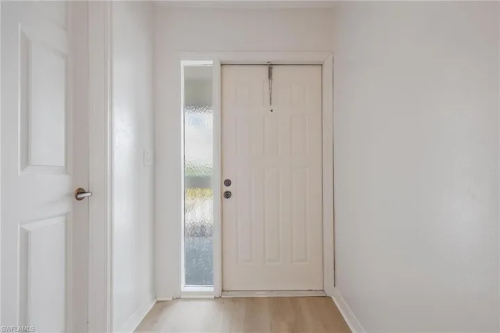 Foyer with baseboards and light wood-style floors