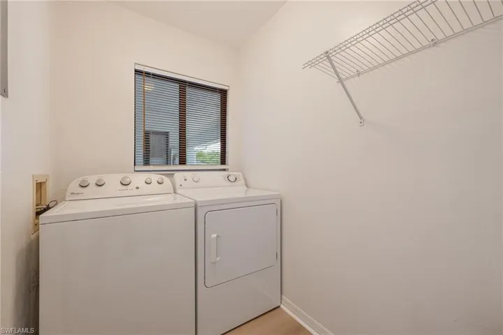 Laundry area with washer and dryer and light wood-style flooring