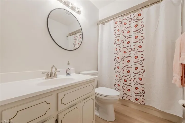 Full bath with vanity and light wood-type flooring