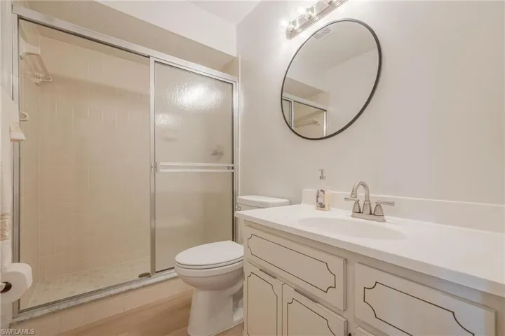 Bathroom with vanity, a shower stall, and light wood-style flooring