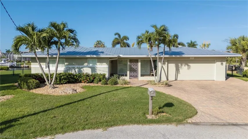 Ranch-style house with a front yard and a garage