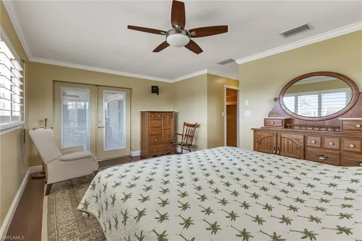 Bedroom featuring french doors, hardwood / wood-style floors, ceiling fan, and multiple windows