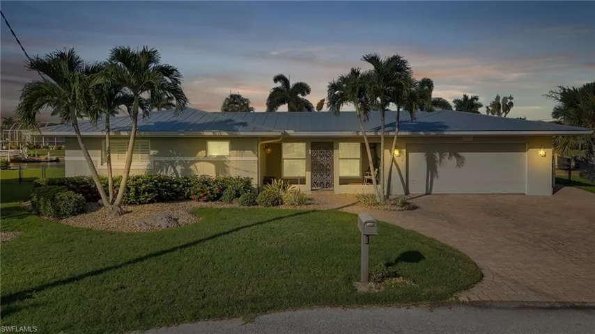 Ranch-style house with a yard and a garage