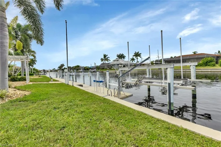 Dock area featuring a water view and a lawn
