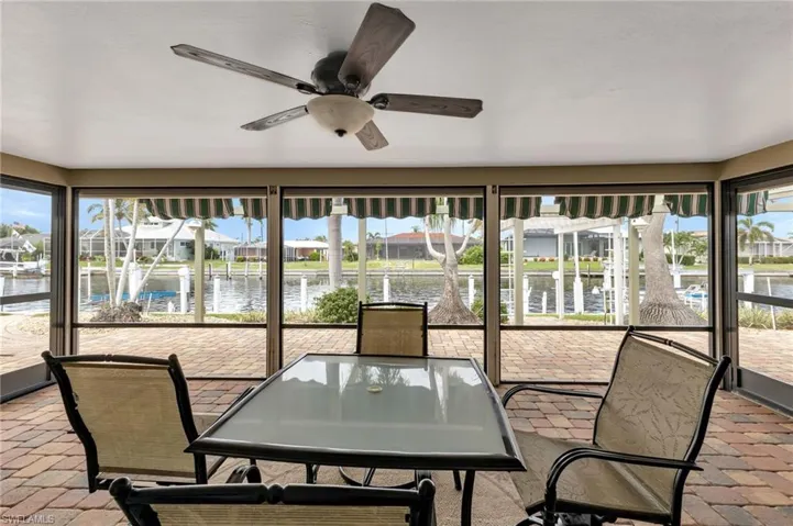 Sunroom / solarium featuring a water view, ceiling fan, and a healthy amount of sunlight