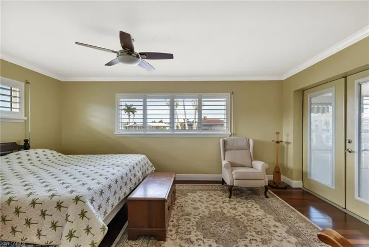 Bedroom with ceiling fan, french doors, access to exterior, ornamental molding, and dark hardwood / wood-style flooring