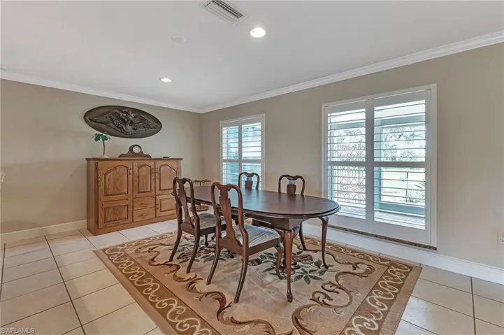 Tiled dining room featuring crown molding