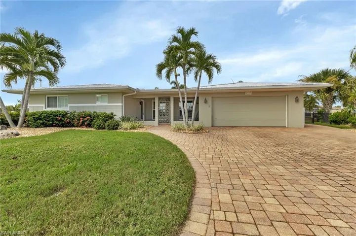 Ranch-style house with a garage and a front lawn