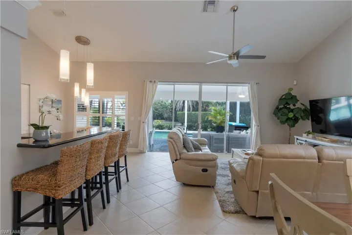 Living area with light tile patterned floors, healthy amount of natural light, and ceiling fan