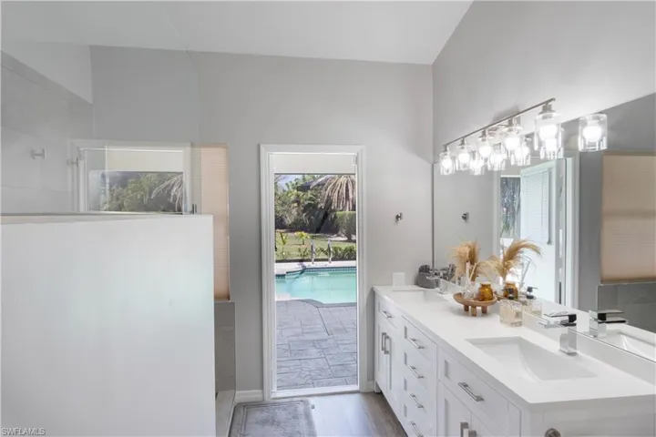 Full bathroom featuring double vanity, light wood-style floors, and a walk in shower