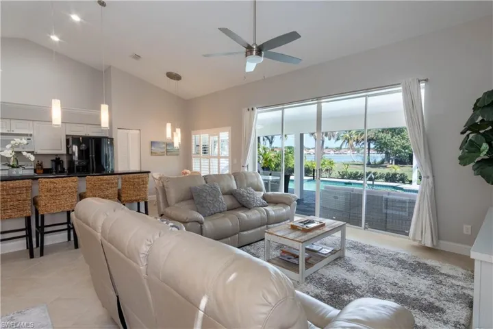 Living area featuring high vaulted ceiling, ceiling fan, and light tile patterned floors