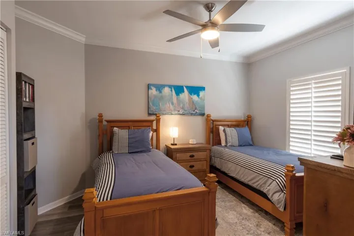Bedroom with ornamental molding, ceiling fan, and wood finished floors