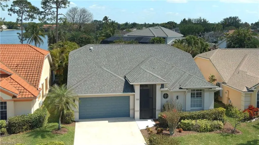 View of front facade featuring concrete driveway, stucco siding, a garage, and roof with shingles