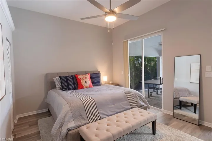 Bedroom with light wood finished floors, access to exterior, and ceiling fan