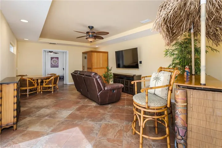Living room with a tray ceiling and ceiling fan