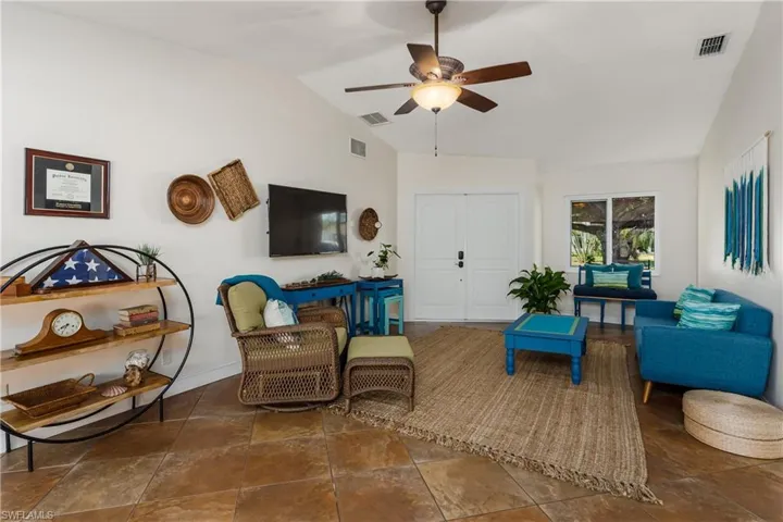 Living area featuring ceiling fan and vaulted ceiling
