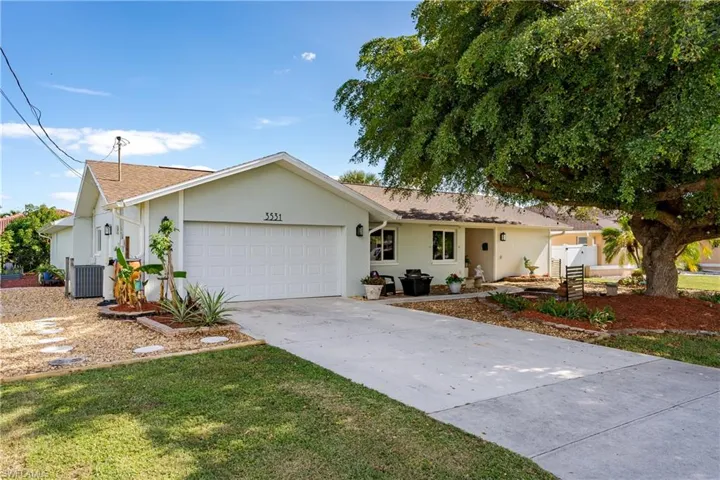 Ranch-style house featuring central AC and a garage