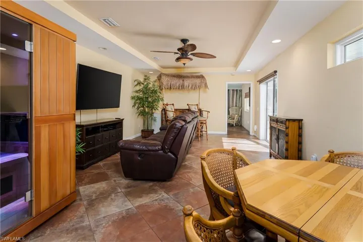 Living room featuring a tray ceiling and ceiling fan