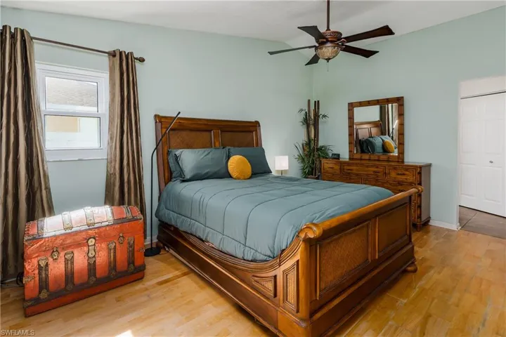 Bedroom with ceiling fan, vaulted ceiling, and light wood-type flooring