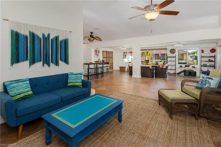 Living room with tile patterned flooring and ceiling fan