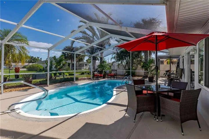 View of swimming pool with a patio and glass enclosure