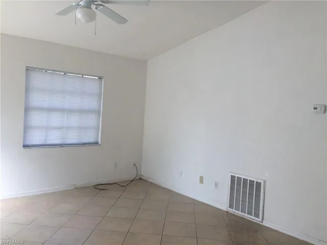 Spare room with a ceiling fan and baseboards