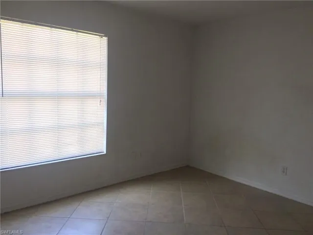 Empty room featuring baseboards and light tile patterned flooring