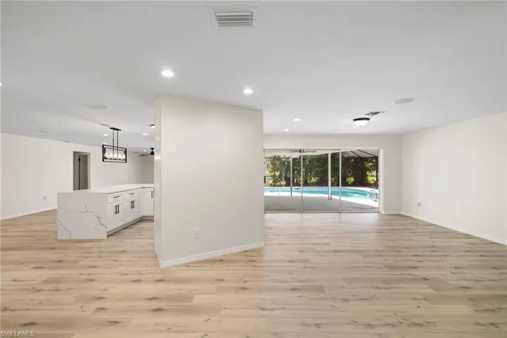 Unfurnished room featuring a sunroom, light wood finished floors, and recessed lighting