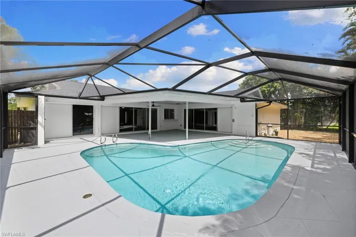 Outdoor pool featuring a patio area and glass enclosure