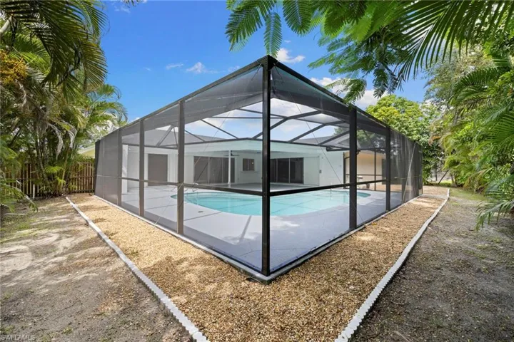 Outdoor pool featuring a patio area and glass enclosure