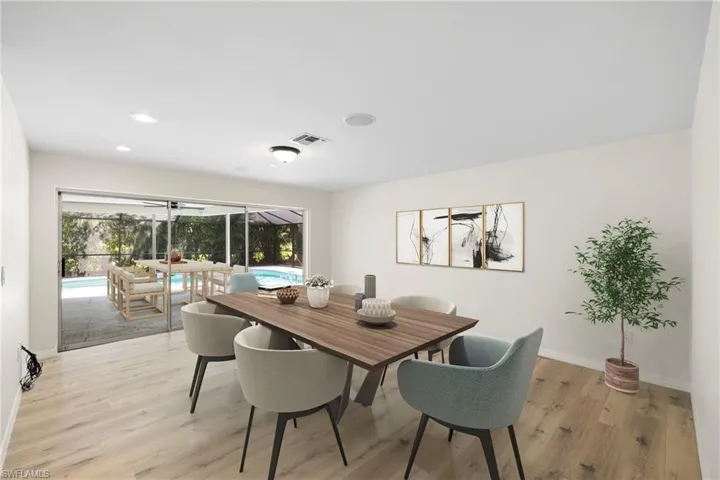 Dining area featuring a sunroom, light wood-type flooring, and recessed lighting