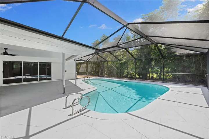 Outdoor pool featuring a patio area, a ceiling fan, and a lanai