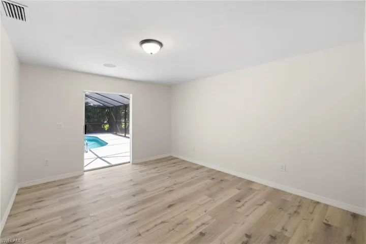 Empty room featuring a sunroom and wood finished floors