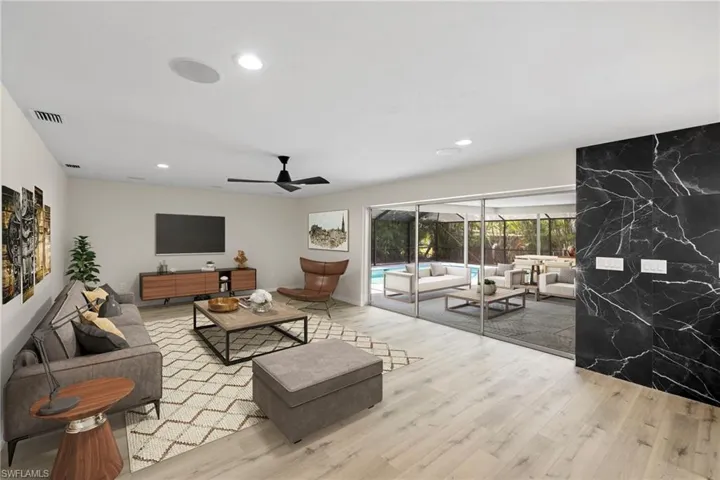 Living room with wood finished floors, recessed lighting, and ceiling fan