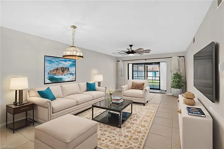 Living room featuring light tile patterned flooring and a ceiling fan