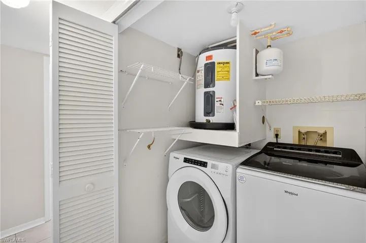 Laundry area with electric water heater and independent washer and dryer