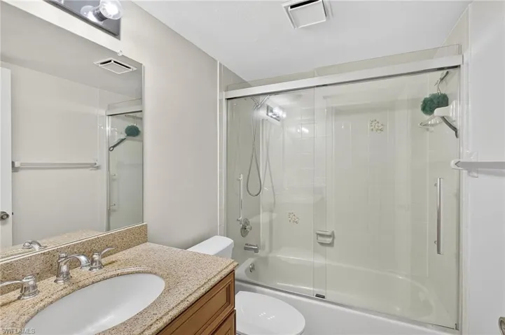 Bathroom featuring enclosed tub / shower combo and vanity