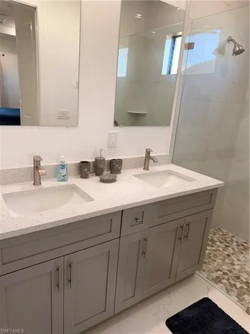 Bathroom with double vanity and a shower stall
