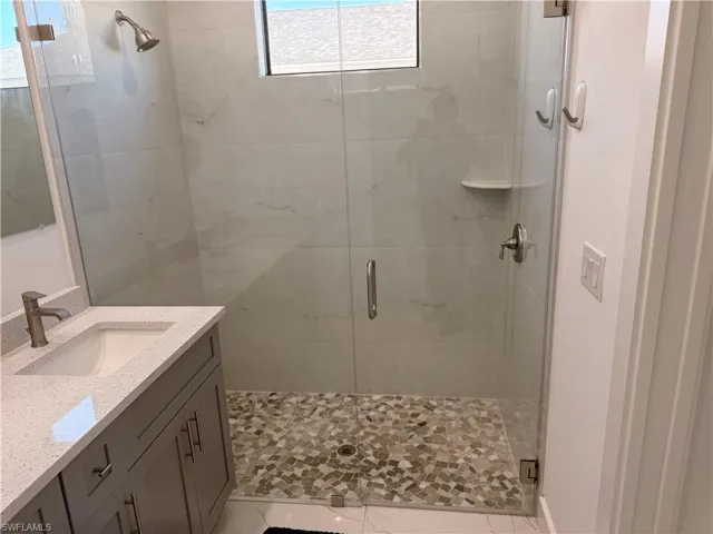 Full bath featuring vanity and a shower stall
