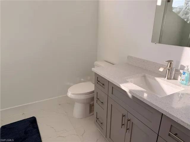 Bathroom with vanity and light marble finish floors