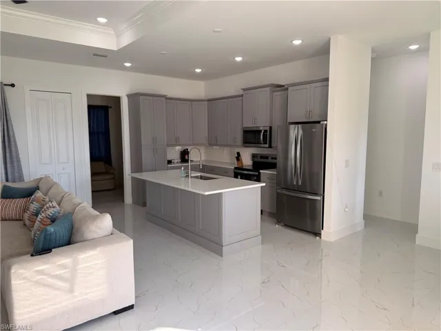 Kitchen featuring gray cabinetry, appliances with stainless steel finishes, recessed lighting, a kitchen island with sink, and tasteful backsplash