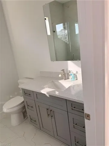 Bathroom featuring vanity, a stall shower, and light marble finish flooring