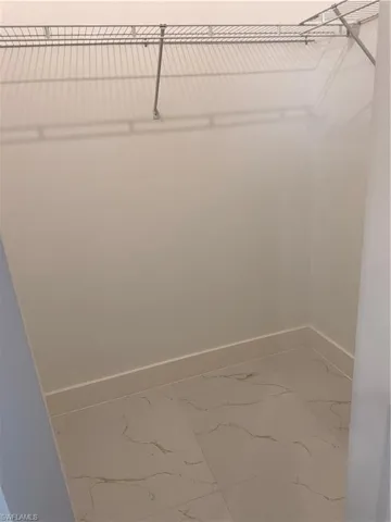 Walk in closet with light marble finish flooring