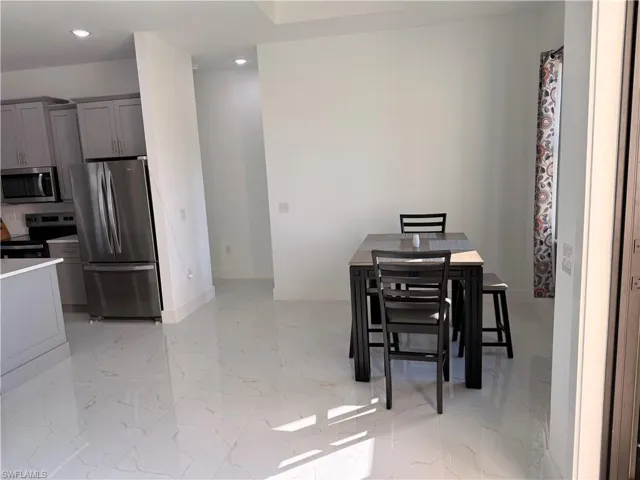 Dining space featuring recessed lighting and light marble finish flooring