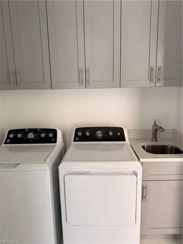 Washroom featuring cabinet space and washer and dryer