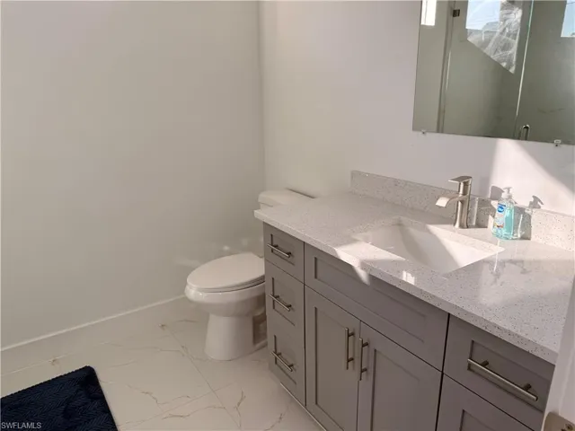 Bathroom featuring vanity and light marble finish floors